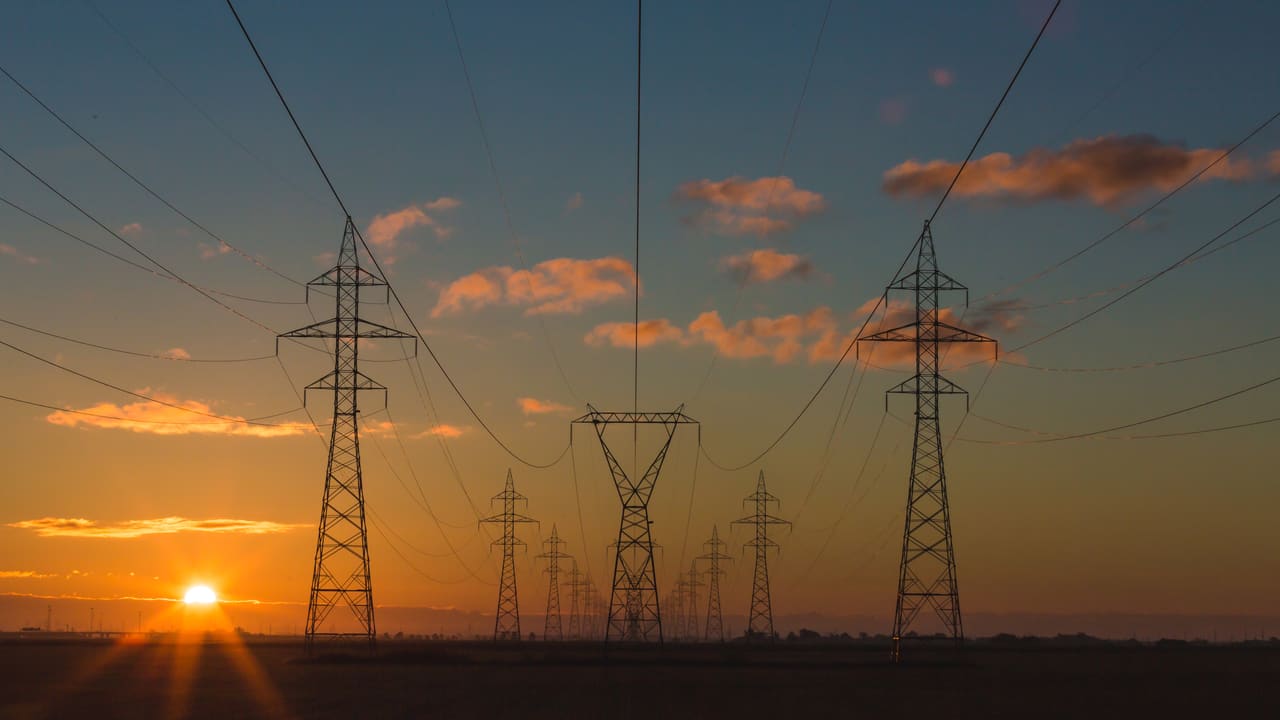 Torres de transporte eléctrico de alta tensión al atardecer