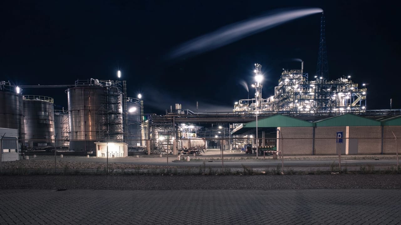 Refinería industrial iluminada durante la noche